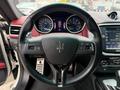 Interior view of a 2016 Maserati Ghibli featuring a stylish steering wheel with the Maserati emblem and a dashboard displaying multiple gauges and a multimedia screen