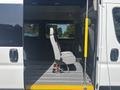 A 2022 RAM Promaster 350 with a single gray driver's seat positioned on a flat, striped floor inside the van