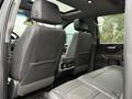 Interior view showcasing the rear seats and center console of a 2022 GMC Sierra 3500HD with leather upholstery and a spacious layout