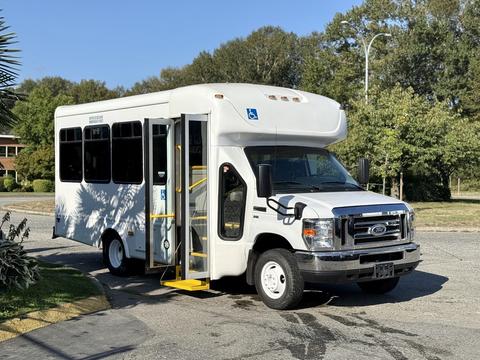 2016 Ford Econoline bus with a wheelchair ramp and large windows parked with the door open