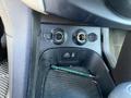 The interior of a 2018 Hyundai Santa Fe showing a console area with a USB port and a power outlet with a pen resting on the textured surface