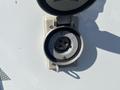 A circular electrical outlet used for connecting power to a 2011 Chevrolet Express with a hinged cover