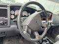 A 2006 Dodge Ram 2500 interior featuring a steering wheel with controls and a dashboard displaying various gauges and digital indicators