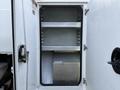 Open door of a 2013 International Durastar 4300 revealing empty shelves and a metal storage compartment inside