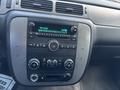 The interior dashboard of a 2011 Chevrolet Avalanche featuring the audio system climate controls and a digital clock display