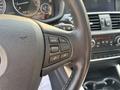 Close-up of the steering wheel controls of a 2013 BMW X3 featuring buttons for phone, volume, and mode settings