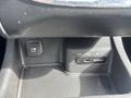 A close-up view of the center console in a 2015 Dodge Durango featuring a 12V DC outlet an AUX port and a USB port