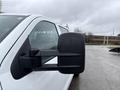 A 2015 GMC Sierra 1500 with a focus on the side mirror showing water droplets on the glass