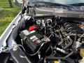 A close-up view of the engine compartment of a 2021 Ford F-150 showing the battery and various engine components under the hood