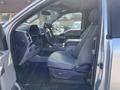 Interior view of a 2015 Ford F-150 showing the driver's seat steering wheel and center console
