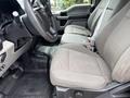 Interior of a 2018 Ford F-150 showing two front cloth seats with seat belts and a part of the steering wheel and dashboard visible