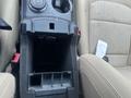 A 2016 Ford Explorer center console with gear shift controls a small storage compartment and cup holders