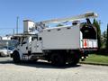 A 2010 Freightliner M2 106 equipped with a raised articulating lift and a large box on the back for tools and equipment