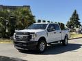 A white 2017 Ford F-350 SD pickup truck is parked with a chrome front grille and shiny wheels