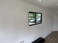 A 2025 Shuttle Office interior with a smooth white wall and a large window revealing an outdoor view