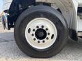 A close-up of the wheel of a 2010 Freightliner M2 106 featuring a white rim and a black tire with the brand name Varisun visible on the sidewall