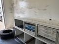 2007 GMC C4500 TopKick truck interior featuring storage cabinets and drawers with visible wear and a tire on the floor