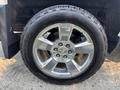 A close-up of a shiny silver alloy wheel with a Chevrolet logo at the center and a thick black tire labeled with the brand name.