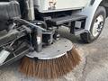 Close-up of the broom attachment on a 2012 International DuraStar 4300 street sweeper with bristles arranged in a circular pattern