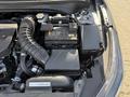 A close-up view of the engine compartment of a 2024 Kia Forte5 showing the battery and other engine components