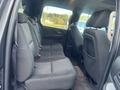 A 2011 Chevrolet Avalanche interior showing the back seat with fabric upholstery and seating for three passengers.