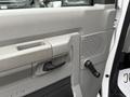 Interior door panel of a 2019 Ford Econoline featuring a handle a window control and a textured speaker grille