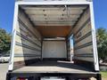Interior of a 2022 Isuzu NQR truck with a spacious cargo area featuring wooden flooring and metal side rails
