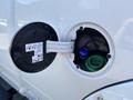 Close-up of a 2018 RAM 3500 fuel filler cap showing a blue DEF cap and a green filler neck inside the compartment