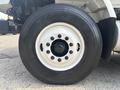 Close-up of a black tire mounted on a white rim showcasing multiple lug nuts with the text Good Year visible on the tire sidewall