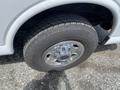 Close-up of a tire and wheel from a 2023 GMC Savana featuring a chrome rim and rugged tread pattern