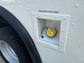 A fuel access compartment for a 2018 Ford Econoline with a yellow cap labeled unleaded fuel only
