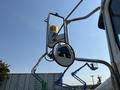 A 2008 Peterbilt 340 truck with a side view mirror and a round mirror showing a reflection of the surrounding area
