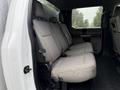 Interior view of a 2020 Ford F-550 showing the rear bench seat with gray upholstery and seatbelts