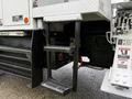 A 2015 Freightliner M2 with metal steps leading up to the cab and visible hydraulic lines and controls on the side