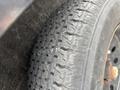 A close-up view of a worn tire showcasing its tread pattern and sidewall details