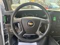 Steering wheel of a 2021 Chevrolet Express with a prominent Chevy logo and control buttons on the side