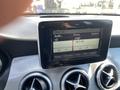 Dashboard display of a 2014 Mercedes-Benz CLA-Class showing audio settings and radio frequency 94.5 FM with control knobs beneath the screen