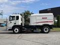 A 2012 Autocar Xpert street sweeper truck featuring a white body with red branding on the side and a large broom attachment at the front