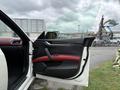 A 2016 Maserati Ghibli door interior featuring black and red leather upholstery with a sleek handle and window controls