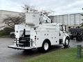 A 2005 Freightliner M2 106 bucket truck with a white exterior featuring a hydraulic lift and utility storage compartments on the back