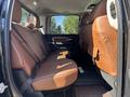 Interior view of a 2015 RAM 1500 showing the backseat with brown leather upholstery and seat belts