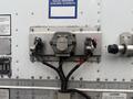 A gray metallic panel with two connections and a central component labeled "PHILLIPS" featuring wiring and colored connectors attached to a trailer façade