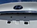 A close-up of the rear exterior of a white 2014 Hyundai Sonata showing the logo and camera mounted above the license plate area