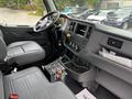 Interior view of a 2025 Peterbilt 536 featuring a modern dashboard with controls a comfortable driver's seat and a central console with various instruments and storage compartments