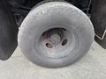 Close-up of a large, worn tire mounted on a 2004 Ford F-350 SD with a steel wheel and visible lug nuts