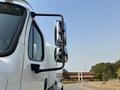 A 2016 Freightliner M2 106 with a prominent side mirror and sleek white exterior showcasing its robust design and large size