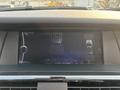 Dashboard display of a 2013 BMW X3 showing a black screen with buttons on either side and a central control interface