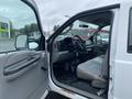A 2005 Ford F-350 SD with an open driver's side door revealing a gray interior and steering wheel.