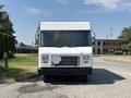 A white 2012 Ford Econoline van with a flat front and large windshield is parked facing forward with a metal grille and no visible side mirrors