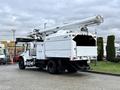 A 2015 Freightliner M2 truck with an aerial lift equipment mounted on the rear and a white utility body designed for maintenance and service tasks